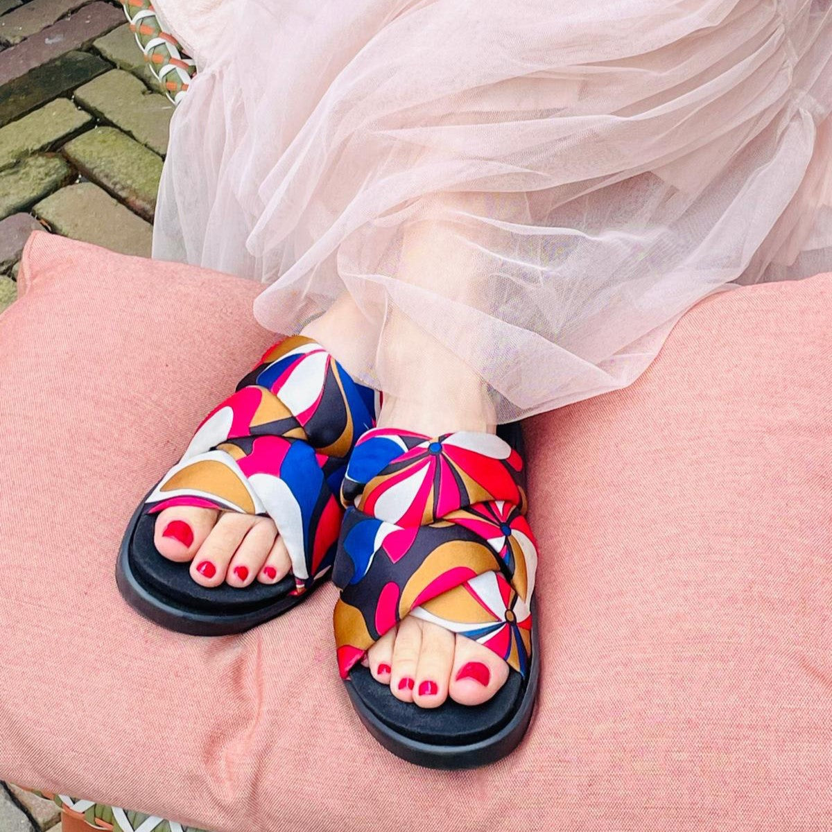 Das Model trägt eine Pantolette in blau, rot, kupfer, schwarz, weiß die sich für orthopädische Einlagen und Hallux valgus eignet