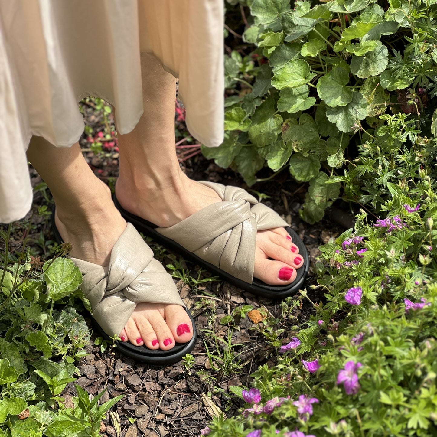 Unser Model trägt eine beige, modische Pantolette. Diese hat ein komfortables Fußbett, das sich gegen eine orthopädische Einlage austauschen lässt.